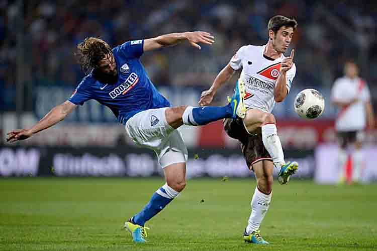 BOCHUM, GERMANY - AUGUST 16: Heiko Butscher of VfL Bochum challenges Fin Bartels of St. Pauli during the Second Bundesliga match between VfL Bochum and FC St. Pauli at Rewirpower Stadium on August 16, 2013 in Bochum, Germany. (Photo by Dennis Grombkowski/Bongarts/Getty Images)